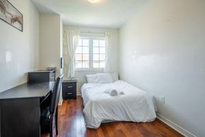 een slaapkamer met een bed, een bureau en een raam bij Beautiful Townhouse In Toronto in Toronto