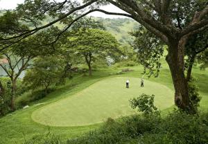 two people playing golf on a golf course at Jeans Holiday Resort in Kandy