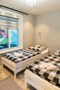 twee bedden in een kamer met een raam bij Domek u Mai in Krośnica