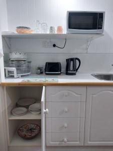a kitchen with a counter top with a microwave at The Treasure Box in Esperance