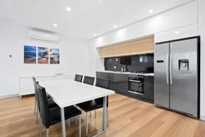 a kitchen with a white table and black appliances at Zahra Lodge in Lorne