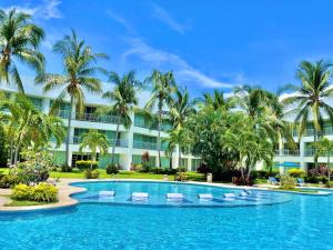 een zwembad met palmbomen en een gebouw bij Vista al Lago con balcón en Mayan Lakes in Acapulco