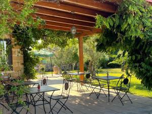 a patio with tables and chairs under a pergola at B&B Terra Cesarea in Santa Cesarea Terme