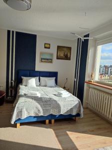 a bedroom with a blue bed and a window at FitoSfera Inez in Jastarnia