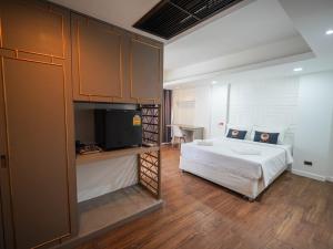 a bedroom with a bed and a flat screen tv at WellQuest Wellness Ladprao Soi 1 in Bangkok
