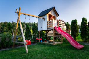 un parque infantil con tobogán y una casa de juegos en Domek u Mai, en Krośnica