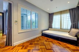a room with a bench in front of two windows at Lone Pine, Penang, a Tribute Portfolio Resort in Batu Ferringhi