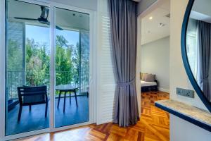 a glass door leading to a balcony with a table at Lone Pine, Penang, a Tribute Portfolio Resort in Batu Ferringhi