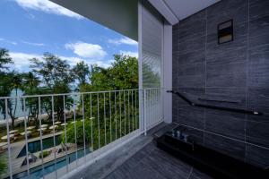 a bathroom with a balcony with a view of the ocean at Lone Pine, Penang, a Tribute Portfolio Resort in Batu Ferringhi