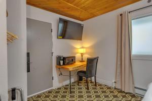 a room with a desk with a microwave and a chair at Highliner Hotel - Deluxe Interior King Rooms- No View in Anchorage