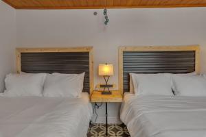 安克拉治的住宿－Highliner Hotel - Deluxe Double Queen with Mountain View，一间卧室设有两张床和一张桌子上的台灯。