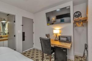a bedroom with a desk with a microwave and a bed at Highliner Hotel - King Rooms with City & Park Views in Anchorage