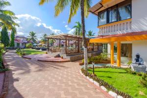 ein Resort mit Palmen und einem Gehweg in der Unterkunft Country Inn Tarika Goa Varca Beach in Varca