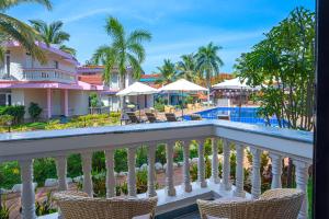 vistas a la piscina desde el balcón de un complejo en Country Inn Tarika Goa Varca Beach, en Varca