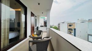 uma varanda com duas cadeiras e uma mesa em BluO 3BHK Golf Course Road - Balcony, Lift, Terrace em Gurgaon