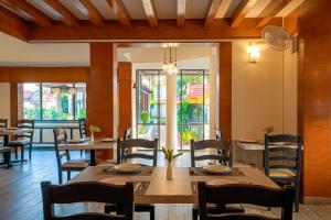 Country Inn Tarika Goa Varca Beach في فاكا: غرفة طعام مع طاولات وكراسي خشبية