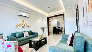 a living room with blue couches and a table at BluO 3BHK Golf Course Road - Balcony, Lift, Terrace in Gurgaon