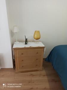 a bedroom with a dresser with a lamp on it at Le Petit Cosy in Saint-Front-la-Rivière