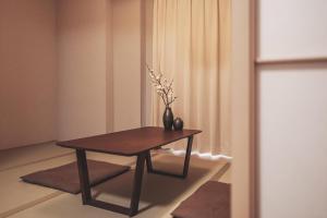a table with a vase on it in a room at 川House道頓堀 in Osaka