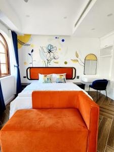 a bedroom with a large bed with an orange couch at LITTLE PHU QUOC STUDIO in Phú Quốc