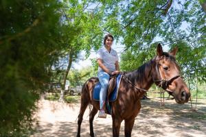 une femme qui roule à cheval sur un chemin de terre dans l'établissement Inno Farms, à Kharar