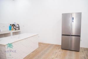 einen Kühlschrank aus Edelstahl in einer weißen Küche in der Unterkunft Jaje Paje Villa in Paje