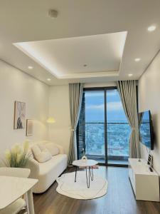 An Lạc的住宿－Lucy Homestay - Hoàng Huy Grand Tower，客厅配有白色沙发和大窗户