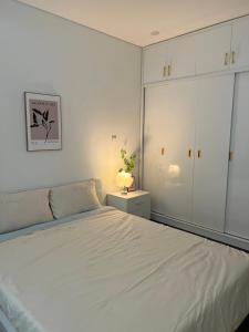 um quarto branco com uma cama e um armário em Lucy Homestay - Hoàng Huy Grand Tower em An Lạc