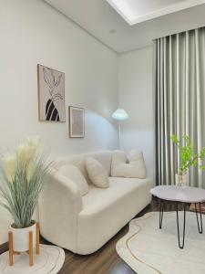 uma sala de estar com um sofá branco e uma mesa em Lucy Homestay - Hoàng Huy Grand Tower em An Lạc