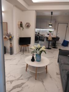 uma sala de estar com uma mesa com flores em Athenian Center Athens Koukaki em Atenas