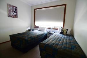a hotel room with two beds and a window at Benalla Apartments in Benalla