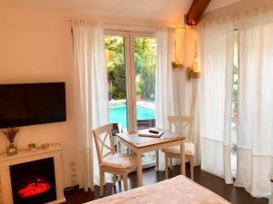 a dining room with a table and a fireplace at Apartment TinyHouse mit Pool, Outdoor Whirlpool und Garten in Petershagen