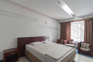a bedroom with a large bed and a window at Istana Hotel Bandung Mitra RedDoorz in Bandung