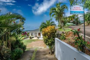 a house with a sign for a malcolmhavenhaven house at Maison D'Aaryan in Anse aux Pins