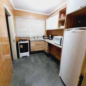 a kitchen with a white refrigerator and a stove at APTO - 1,3 km da AFONSO PENA - 3 quartos com ar condicionado in Campo Grande +34 photos