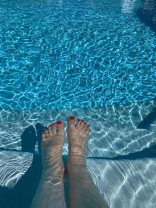 a persons feet standing next to a swimming pool at Insolite avec piscine Au Bonheur Comtois in Ronchamp