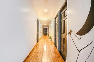 a hallway with wood flooring and a hallway with doors at FabExpress PP Residency in New Delhi