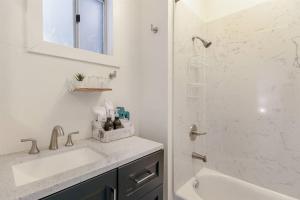 uma casa de banho branca com um lavatório e um chuveiro em Modern Apt near all conveniences em Oakland