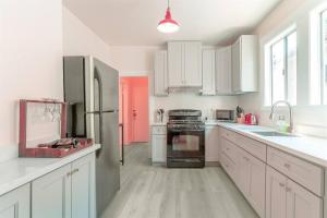 a kitchen with white cabinets and a red door at Modern Apt near all conveniences in Oakland