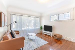 a living room with a couch and a tv at Modern Apt near all conveniences in Oakland