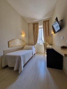 a bedroom with a bed and a flat screen tv at Hotel Virgilio in Orvieto