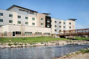 a building next to a river with a bridge at TownePlace Suites by Marriott Logan in Logan