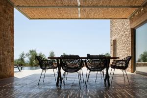 einen Tisch und Stühle auf einer Terrasse in der Unterkunft Riverstone Villas with private pools in Lévktron
