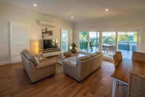 a living room with two couches and a table at Baileys Cottage in Adamstown