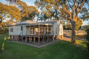 a modular home with a porch and a tree at Baileys Cottage in Adamstown