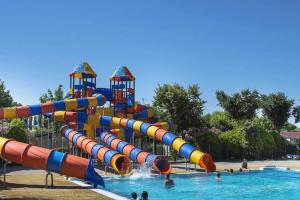 a water park with a water slide in a pool at Bungalow in Caorle with garden furniture in Caorle