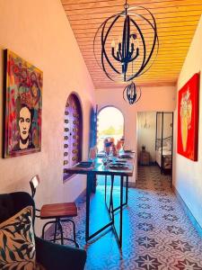 een eetkamer met een tafel en een kroonluchter bij Casa Capilla @ Casa Frida Valle de Gpe in San Marcos