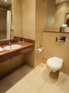 a bathroom with a toilet, sink, and mirror at Great National Hotel Ballina in Ballina