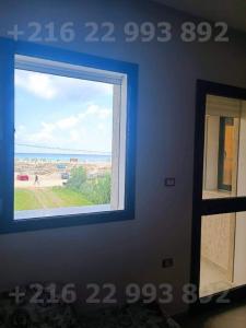 uma janela num quarto com vista para a praia em S 2 high standing waterfront in Dar Allouche Kelibia Nabeul em Hanshīr Qaşr Ghallāb