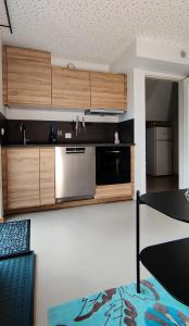 a kitchen with wooden cabinets and a table in a room at Modern and comfortable apartment in attractive neighborhood in Stavanger